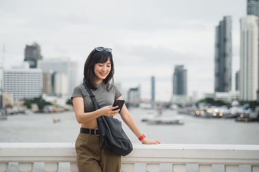 Happy young southeast asian woman teenager blogger searching map guide smartphone. World travel explorer local cultural experience tourism concept Bangkok Thailand near Chao Phraya River Asia photo