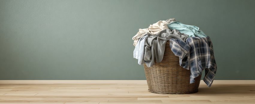 The overflowing laundry basket filled with assorted clothes in a cozy room. photo