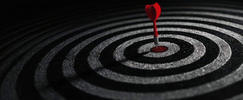 The dart hitting the bullseye of a concentric target design. photo