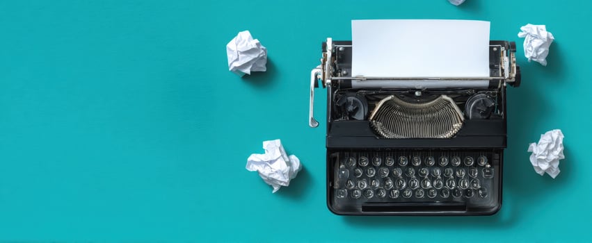 The vintage typewriter with blank paper and crumpled balls around it photo