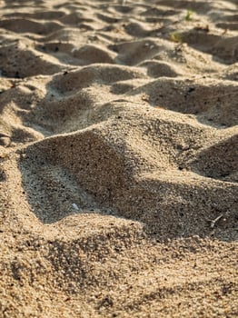 High resolution image of fine beach sand with subtle natural grain texture captured under sunlight perfect for background use in design or organic product presentation Textured Sand Close-Up with Gent photo