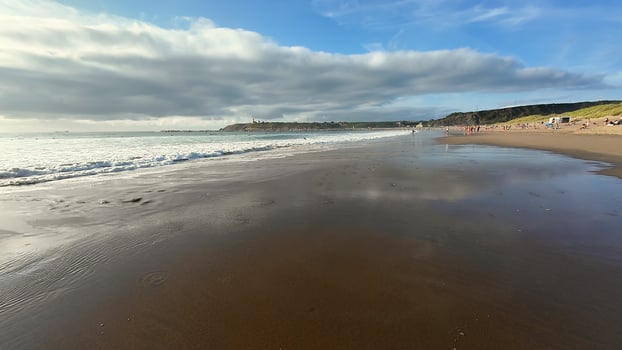 A serene and peaceful beach landscape showcasing smooth, soft sand, gentle waves, and a beautiful bright sky photo
