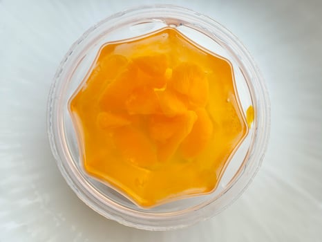 Mandarin orange slices in jelly on a plate on a white table. photo