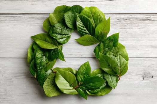 Fresh green leaves neatly arranged in a circular formation on a rustic wooden table symbolize nature and sustainability efforts photo