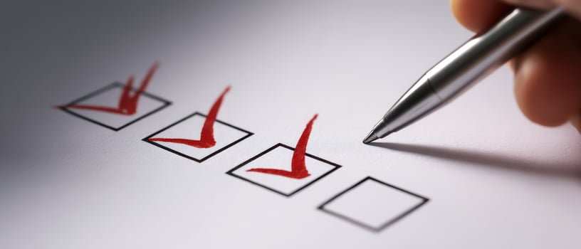 The pen marking a checklist with red checkmarks on paper photo