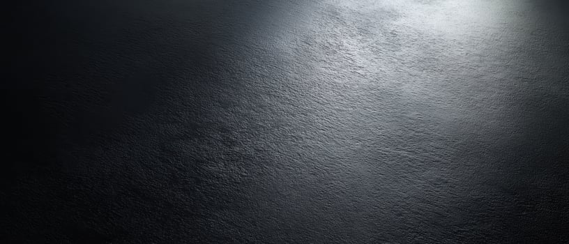 The smooth black surface illuminated by subtle highlights and shadows. photo