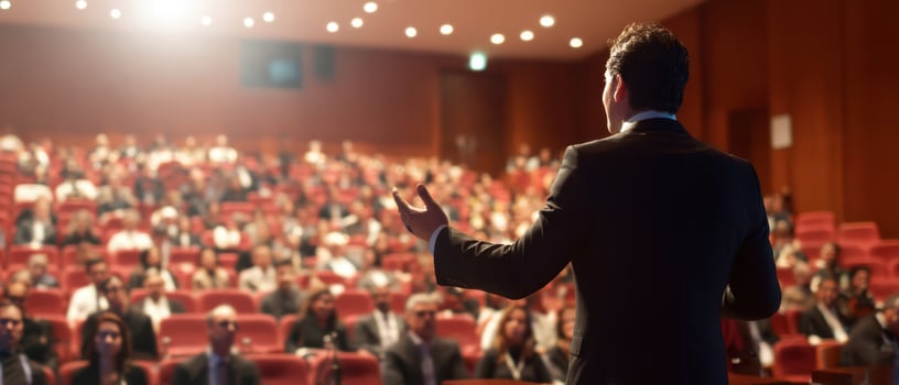 The speaker engaging a captivated audience during a professional conference event. photo