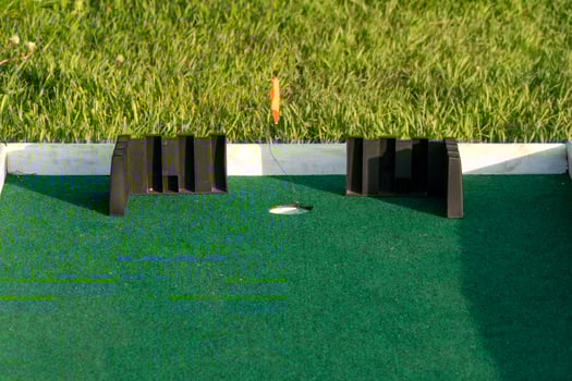 Miniature Golf Course Hole with Green Turf and Barriers Outdoors photo