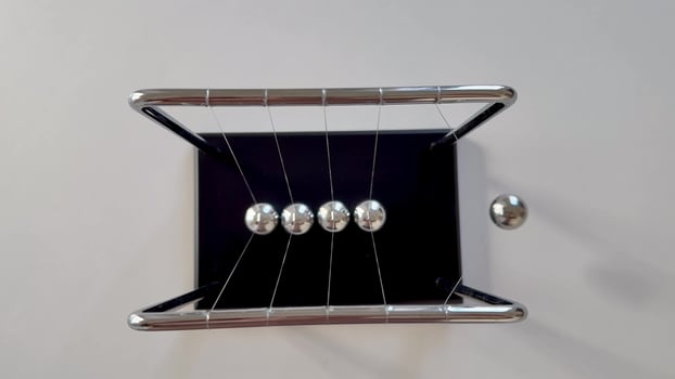 A Newtons Cradle, elegantly displaying the essential principles of momentum and energy transfer using steel balls photo