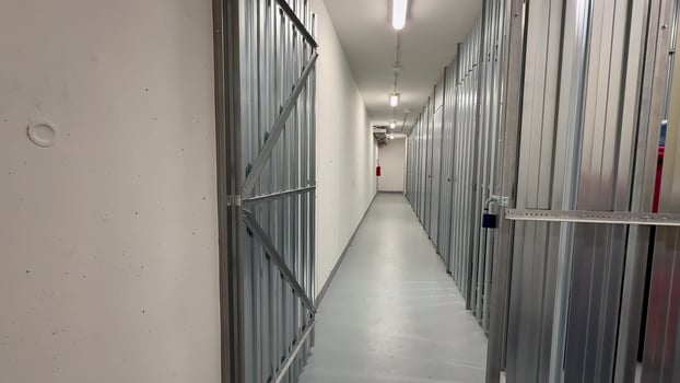 A long corridor elegantly lined with multiple secured storage units, effectively showcasing a modern storage facility photo