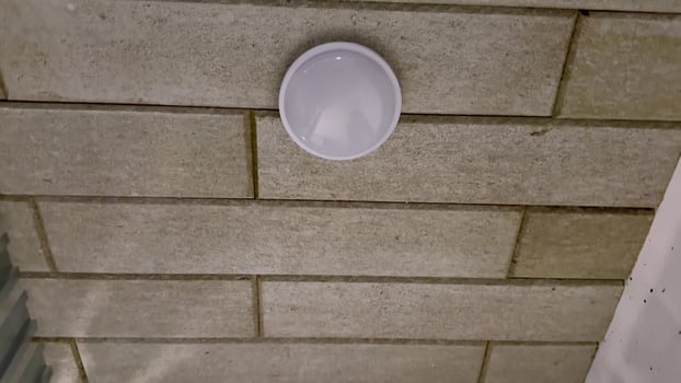 A sleek, modern ceiling light fixture beautifully mounted on a textured wall, enhancing the ambiance and style photo