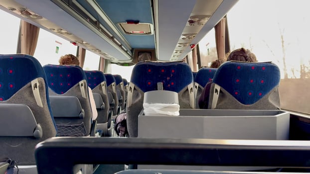 A spacious and inviting interior of a modern bus, showcasing comfortable seating and a sunny, cheerful ambiance photo