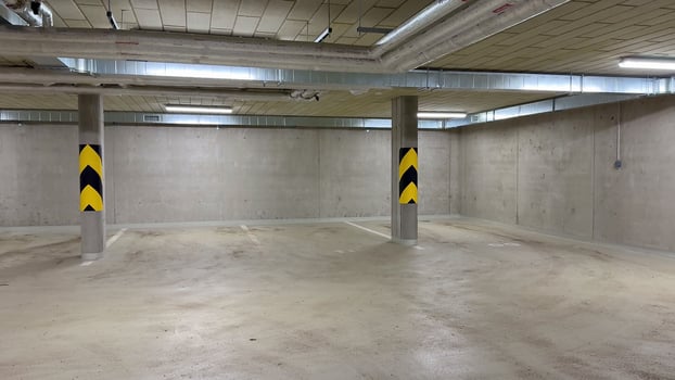 A comprehensive and detailed view of an underground parking garage showcasing ceiling infrastructure and piping systems photo