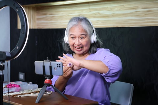 Senior Woman Live Streaming Jewelry Sale Online, Mature Female Vlogger Presenting Handmade Jewelry, Elderly Entrepreneur Selling Accessories Through Social Media photo