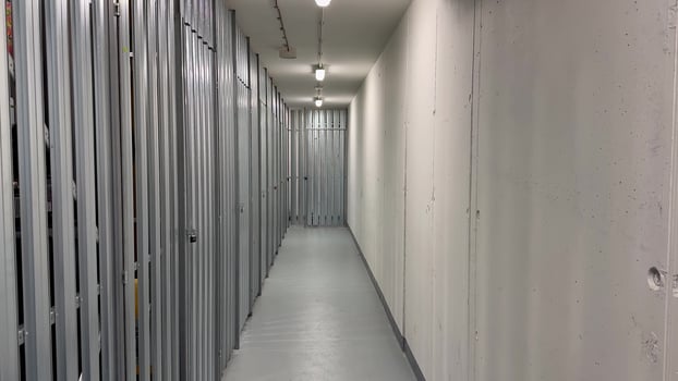 The clean, welllit hallway includes secured storage units in a large facility, ensuring your belongings safety photo