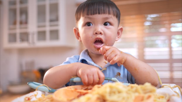 Happy Asian boy enjoying mealtime in the kitchen,247 photo