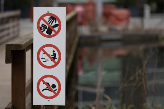 Prohibition Sign Detail with Red Circles on Wooden Railing at Lakeside photo