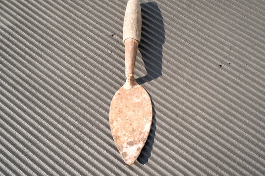 A rusty trowel with a wooden handle isolated on black backgrounds. Hand shovel used for planting plants in pots or digging soil. Tool and equipment for gardening . Graphic resources. Copy space photo