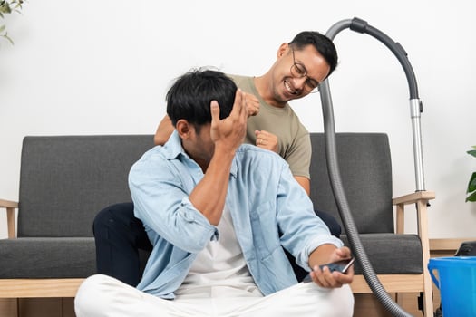 Couple Sharing a Light Moment While Cleaning at Home. Joyful interaction during chores. photo