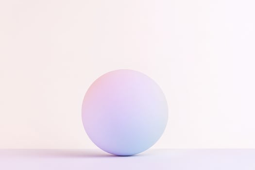 A single smooth sphere features a soft gradient of color, positioned centrally on a light-colored surface, highlighting its elegant simplicity photo