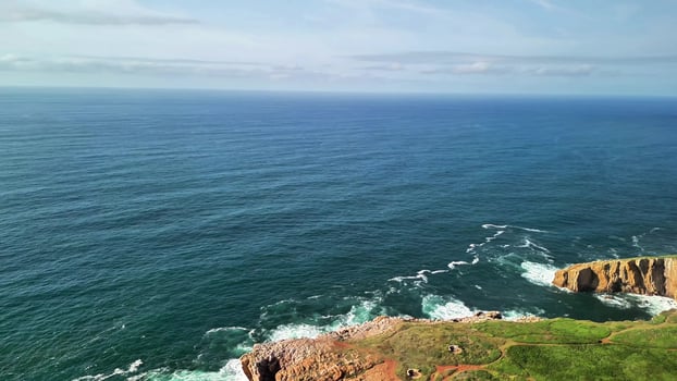 Experience stunning aerial shots of coastal cliffs, tranquil ocean, and clear skies inviting adventure photo