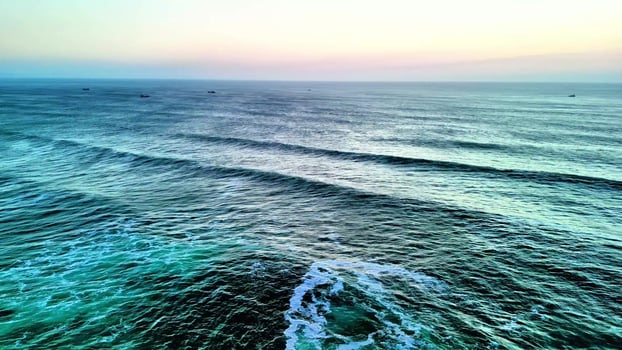 A breathtaking view of the ocean waves in calming colors during sunset, perfect for relaxation visuals. photo
