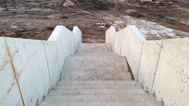 A captivating view of a series of concrete steps that are descending into an unfinished construction area photo