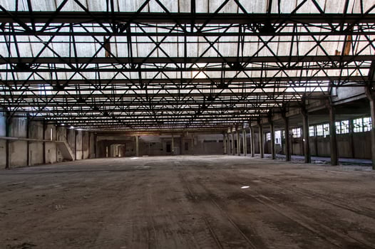 Huge abandoned space of a ruined factory photo