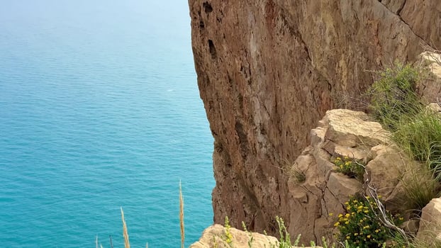 Majestic cliffs tower above a tranquil blue sea under a clear sky, offering breathtaking views that await you photo