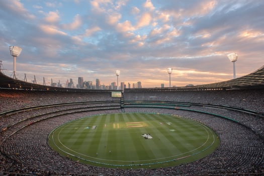 Many spectators fill the stands at Melbourne Cricket Ground, cheering for their teams during a thrilling cricket match at sunset photo