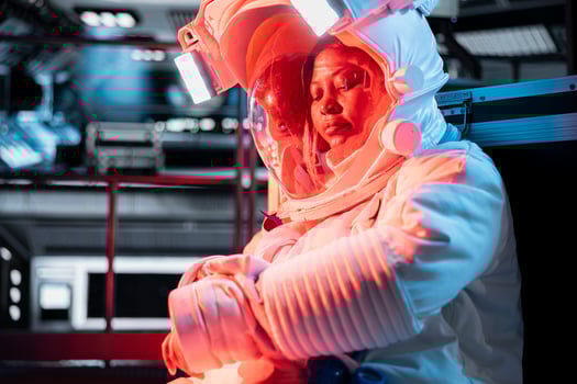 Woman in malfunctioning starship activates onboard backup systems. Female astronaut pressing wrist touchscreen display to take protective measures, alerted by emergency red lighting photo