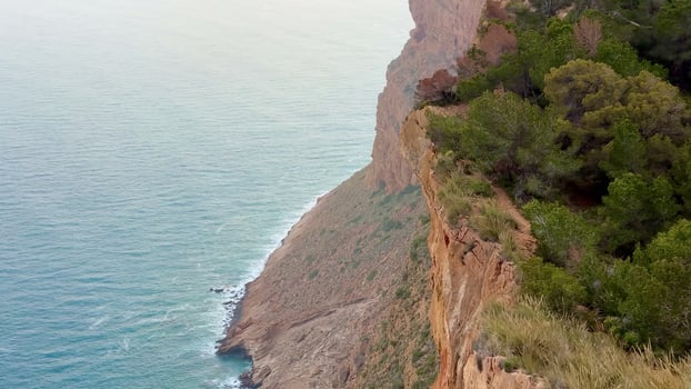 A stunning view of a rugged coastal cliff meeting the calming ocean below, perfect for nature lovers and adventurers photo