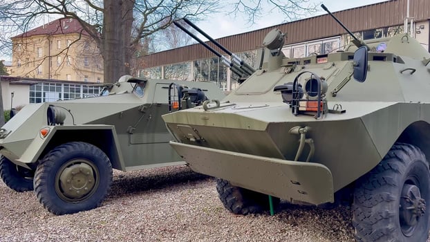 Two distinct military armored vehicles in green display their weaponry, signifying readiness for action photo