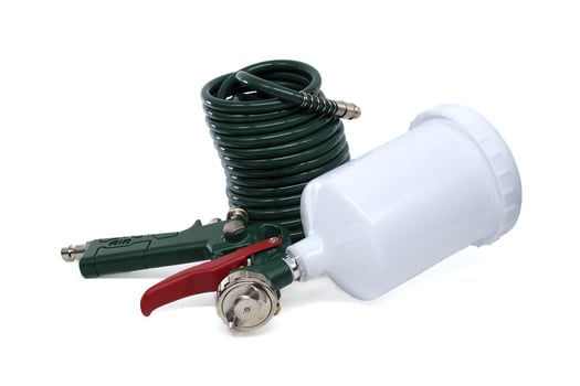 A professional spray gun with a green hose and paint container, isolated on white backdrop. photo