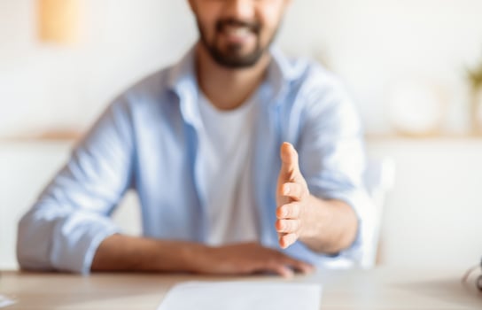 Partnership Concept. Friendly Young Businessman Giving Hand For Handshake At Camera, Positive HR Manager Greeting Somebody And Offering Cooperation In Office, Cropped Image With Selective Focus photo
