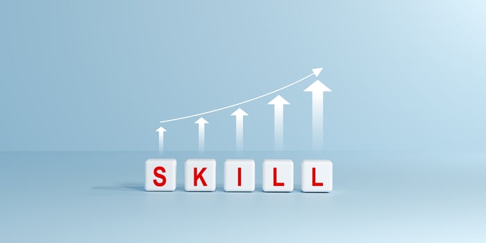 White cubes spelling SKILL with an upward trending line graph and arrows. Symbolizes skill development, learning, growth, continuous improvement in education, career, personal development concepts. photo