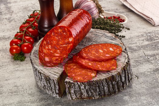 A slice of salami on a wooden cutting board photo