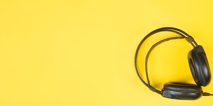 Black studio headphones on a yellow background. Banner with place for text. Flat lay, copy space. photo