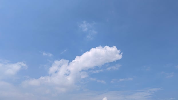 Serene Blue Sky Landscape with Fluffy White Clouds on a Sunny Day photo