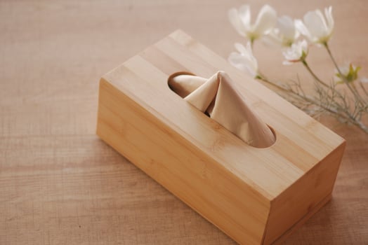 Elegant wooden tissue box with flowers on table photo