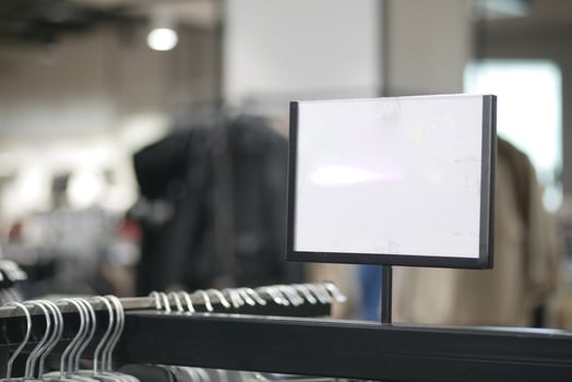 Black hanger rack in a clothing store with empty signage photo