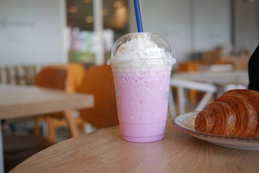 Refreshing pink drink and croissant in a cafe photo