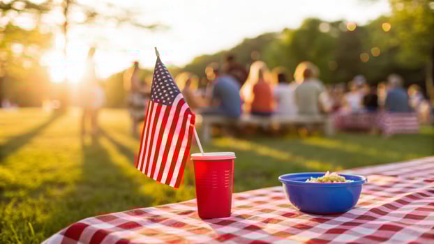 Independence day celebration. Patriotic picnic table with American flag, red cup, blue bowl, outdoor family, family gathering holiday, 4th july photo