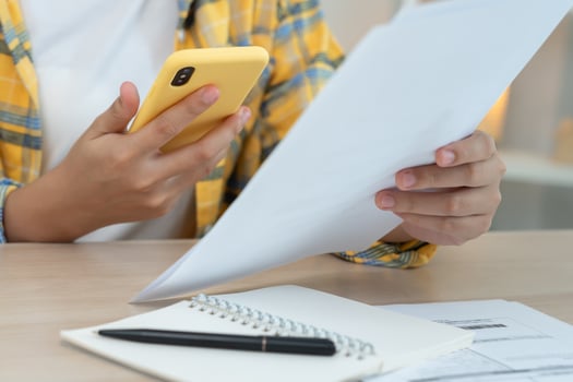 woman use phone scan barcode or QR codes to pay credit card bill after receiving document invoice. payment, receive, paying electricity, digital payments, technology, scanning, financial transaction. photo
