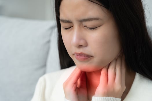 Asian woman put on neck due to a sore throat. female tonsillitis causes a inflammation. treated by taking water, taking antibiotics, consult a doctor, virus, corona virus, Influenza. photo