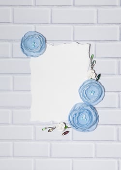 White Background With Blue Handmade Ranunculus Flowers and Empty Place for Text photo