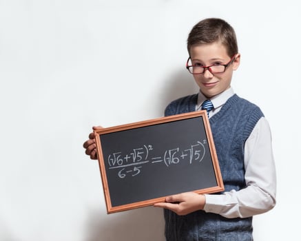 Schoolboy in glasses with mathematical equation on charcoal desk photo