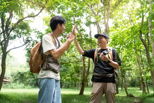 Father and Son Celebrating Together. Sharing a high-five in a vibrant outdoor setting. photo