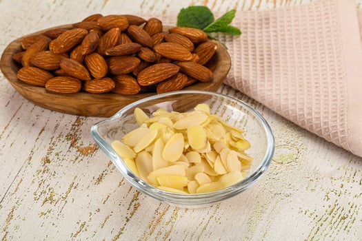 Almonds and almonds in a bowl on a wooden table photo