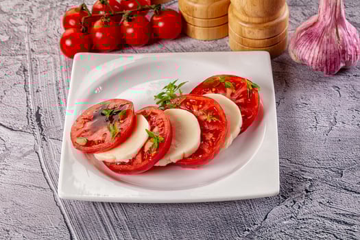 A plate with sliced tomatoes and garlic photo